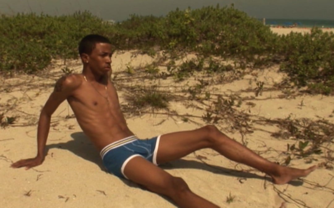 Schöner Mann am Strand Entblößt