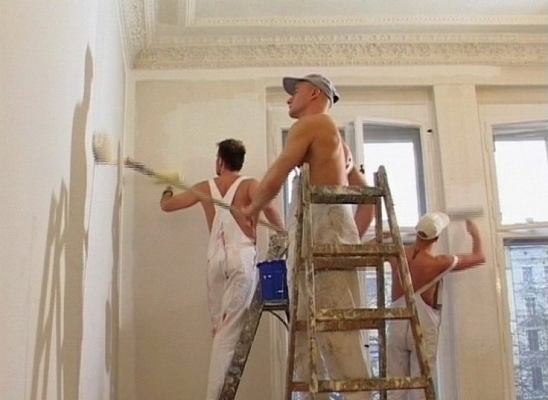 Three macho workers in hot spraying action